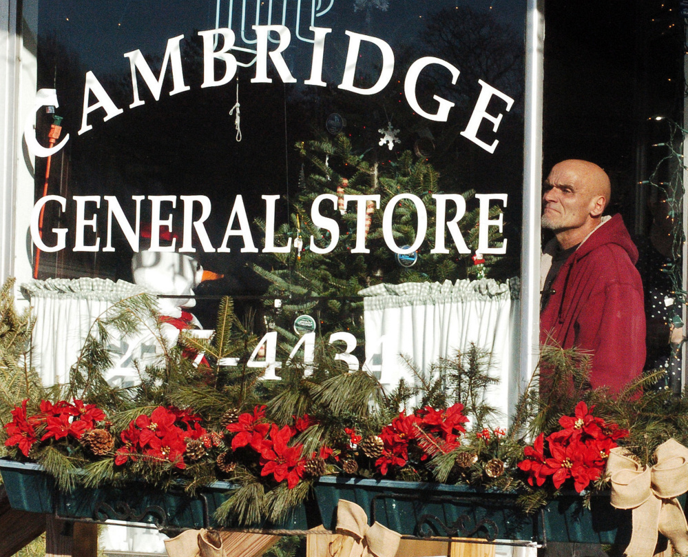 Mechanic Greg Davis, who leased Bunker's Garage, watches from the Cambridge General Store and Restaurant as flames engulf the beloved Garage on Dec. 11.