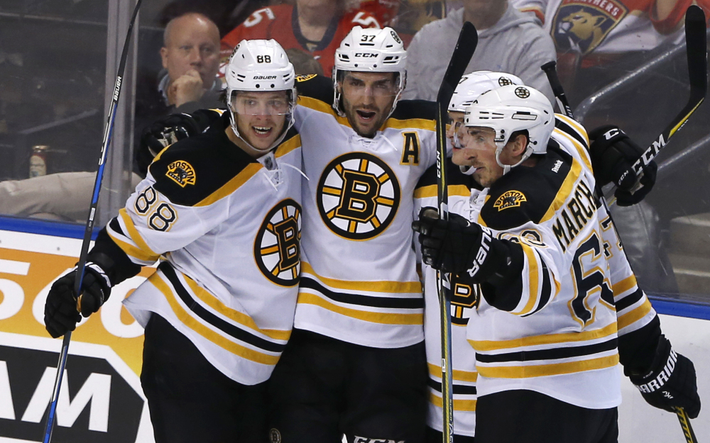 Boston's Patrice Bergeron, 37, celebrates his second-period goal with David Pastrnak, 88, Brad Marchand, 63, obscured, and Torey Krug in Thursday night's game at Sunrise, Fla.
