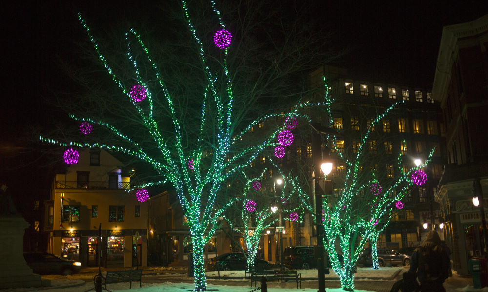 Trees covered in holiday lights brighten up Longfellow Square in Portland. The traditions observed in America's Christmas come from all corners of the Earth and from observances both religious and secular.