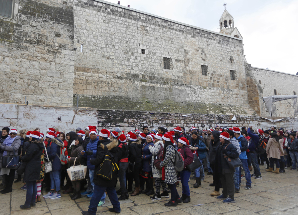Christian pilgrims wearing red Santa hats wait in line to enter the Church of the Nativity, built atop the site where Christians believe Jesus Christ was born, on Christmas Eve.
