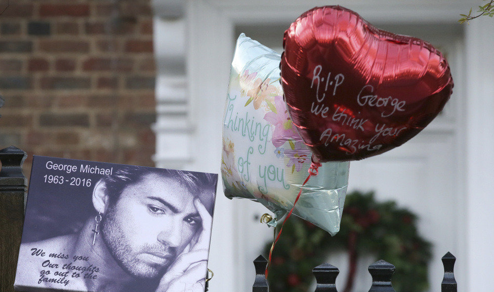 Tributes are left on the gate outside the home of British musician George Michael in London on Monday. Michael died of apparent heart failure at age 53.