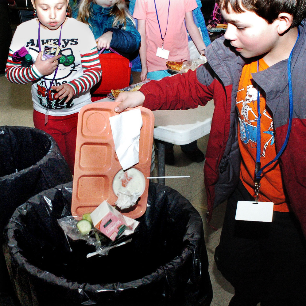 Winslow Elementary School student Aidan Giguere and other students empty food waste into trash cans in the school cafeteria on Dec. 22. Winslow is looking at a food waste recycling program for the school.
David Leaming/Morning Sentinel