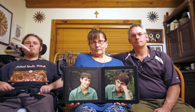 The Norton family is mourning "JT" Norton, who had schizophrenia. From left are brother Michael, mother Suzan – holding a photo of JT when he was younger – and father Terrence.