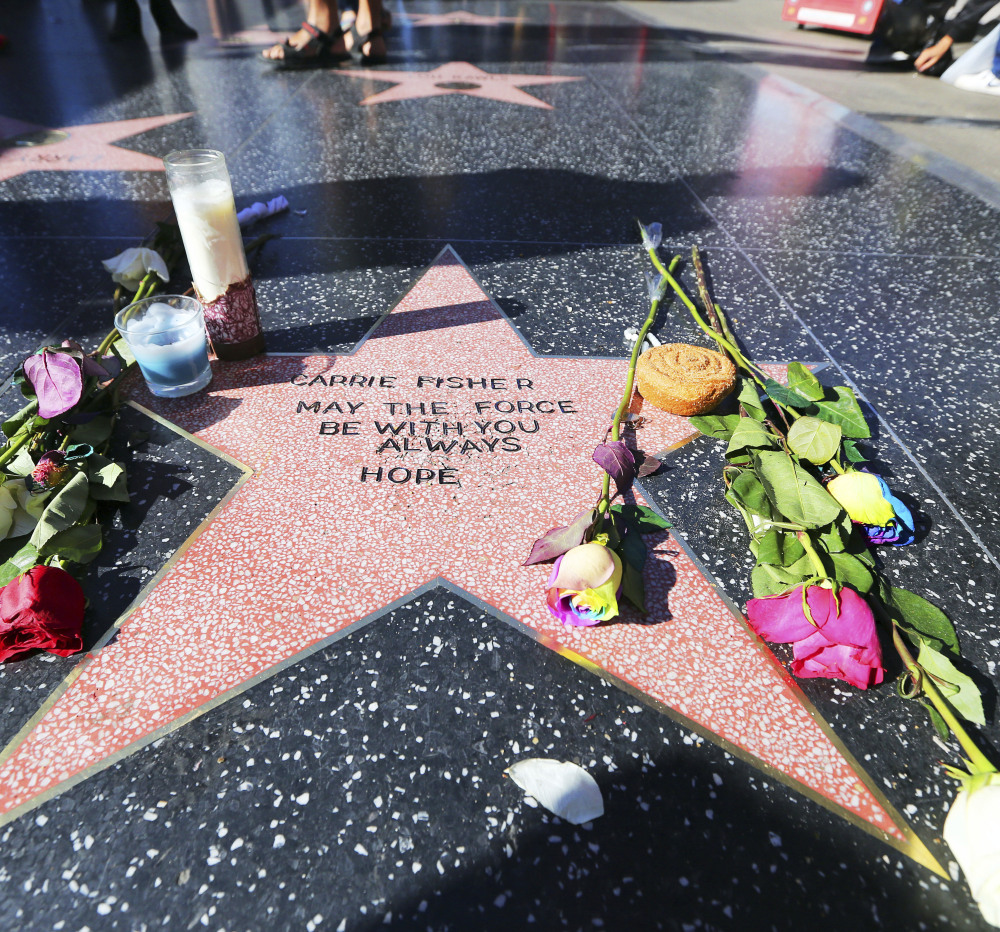 Flowers, candles and the phrase "May the force be with you always" adorn an impromptu memorial to Carrie Fisher in Hollywood.