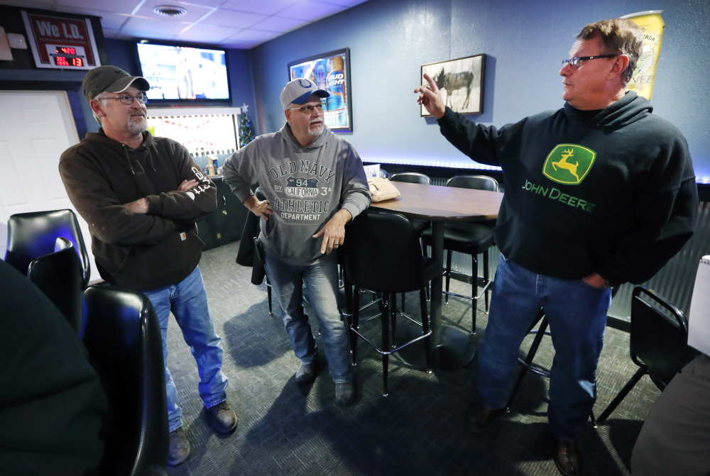 Ron Oberhelman, right, talks with Rod Nelson, left, and Jeff Thompson in their Blue Moose Saloon, which opened in September in Renwick, Iowa. Oberhelman, a 59-year-old farmer who has seen the population fall from about 500 to 235 residents says, "It's not our hometown. When your local place closes up, you're pretty much lost."