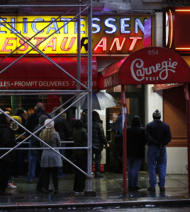 People wait in line to eat at the Carnegie Deli in New York on Thursday. After 79 years of serving up heaps of cured meat, the Carnegie shut down for the last time Friday.