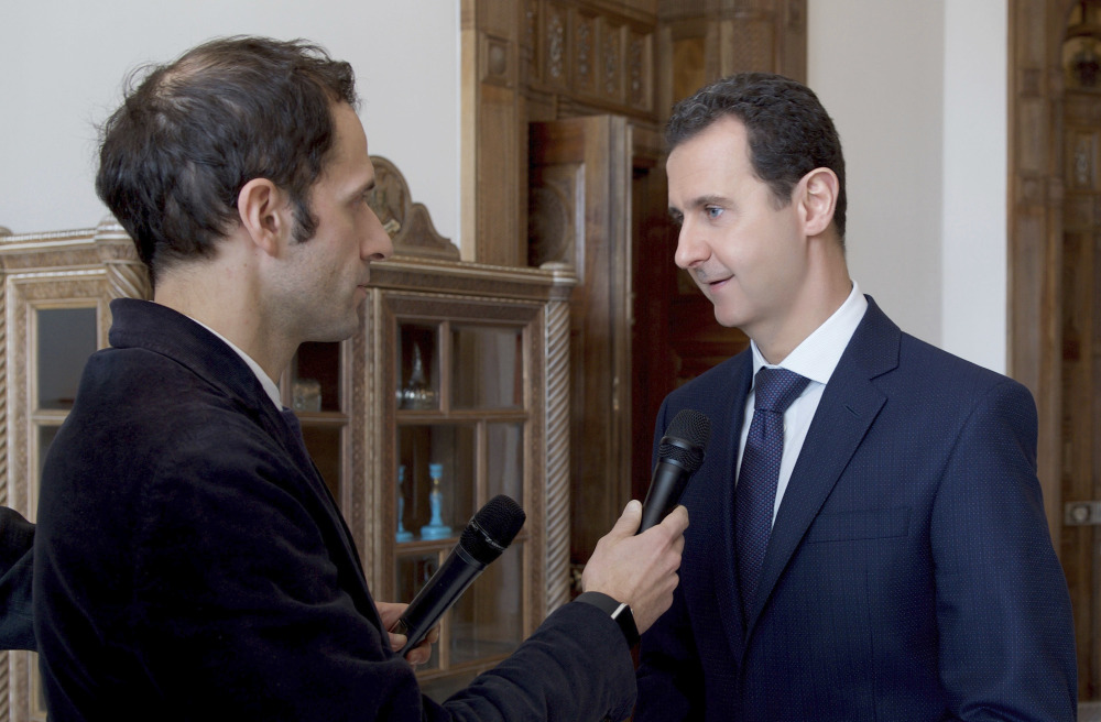 Syrian President Bashar al-Assad, right, is interviewed by Italian TV station TG5 in Damascus, Syria, on Friday. "We are more optimistic, with caution," he said, about President-elect Donald Trump, who has suggested greater cooperation with Russia, a Syrian ally.