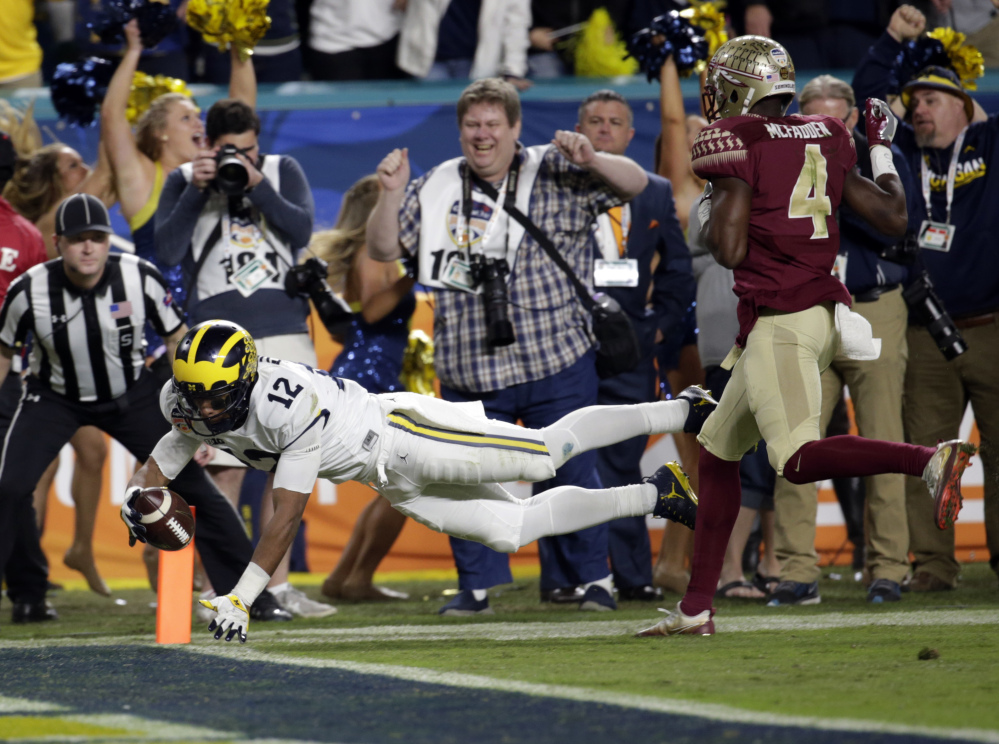 Michigan running back Chris Evans dives to finish off a 30-yard touchdown run and give the Wolverines the lead late in the fourth quarter.