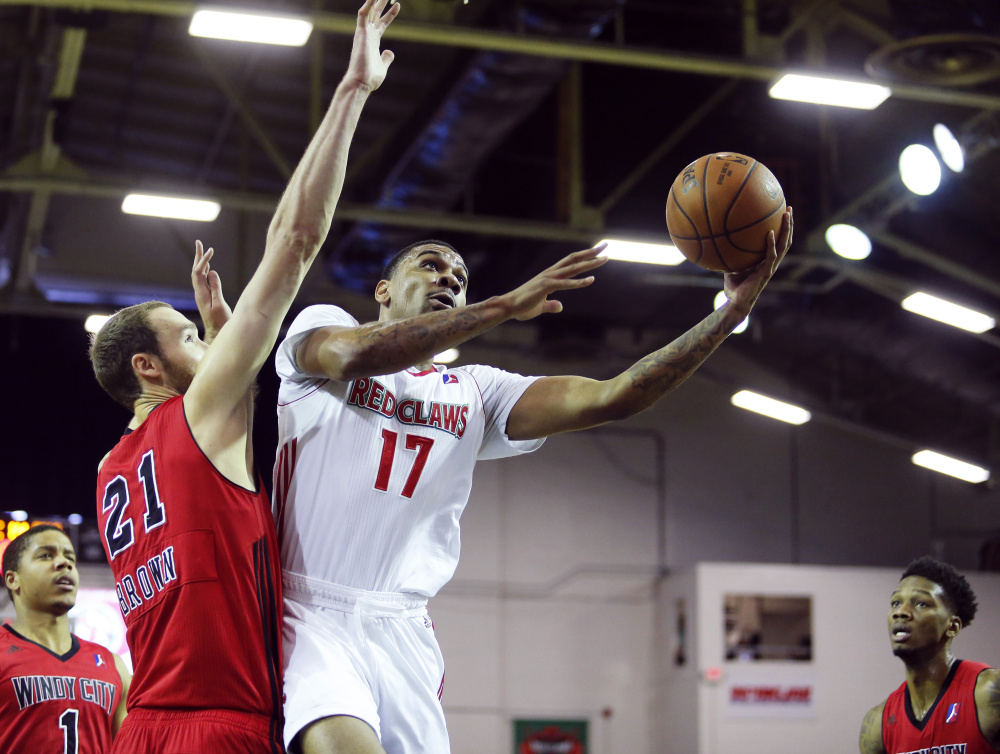Arthur Edwards of Maine reaches around Alec Brown of Windy City to put up a shot during the first half of Saturday's game at the Portland Expo. The Red Claws won, 117-106. (Derek Davis/Staff Photographer)