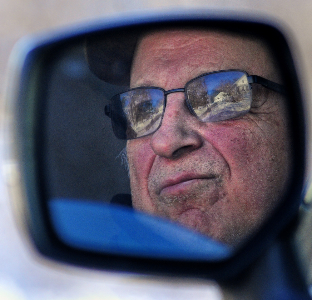 Lionel Quirion is reflected his car mirror Saturday while he sits in the car and looks for birds at the feeders on Leavitt Road on in Augusta.