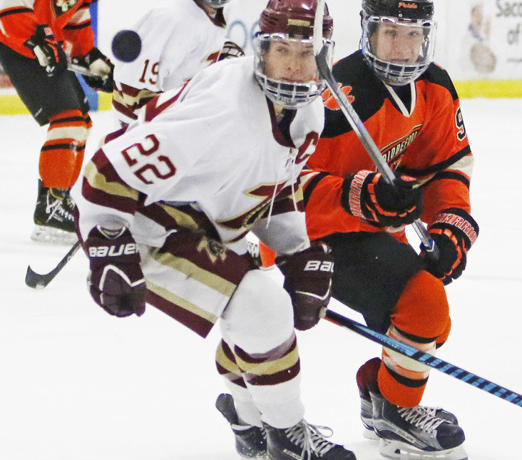 Chase Wescott, left, of Thornton Academy and Tyler Laflamme of Biddeford keep their eye on the puck during a Class A South hockey game Saturday at Biddeford Ice Arena. Biddeford won, 3-0.