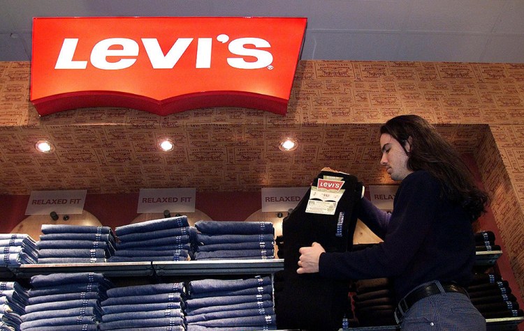 A store employee stocks a Levi's jeans display at a downtown Toronto department store. <em> Associated Press/CP Kevin Frayer</em>