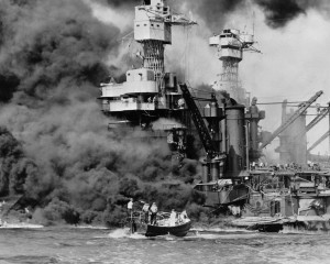 In this Dec. 7, 1941 photo, a small boat rescues a seaman from the USS West Virginia burning in the foreground in Pearl Harbor, Hawaii, after Japanese aircraft attacked the military installation. More than 2,300 U.S. service members and civilians were killed in the strike that brought the United States into World War II. U.S. Navy via AP 
