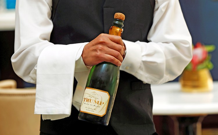 A waiter opens a bottle of Trump champagne for the first guests to arrive at the Trump International Hotel on its "soft opening" day in Washington on Sept. 12, 2016. <em>Reuters/Kevin Lamarque</em>