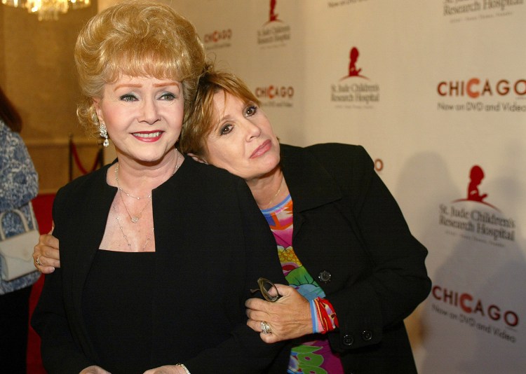 Debbie Reynolds gets a hug from her daughter Carrie Fisher at a charity event in Beverly Hills, Calif., in 2003. When Reynolds passed away this week, her son said the stress of Fisher's death the day before was too much for his mother to take.