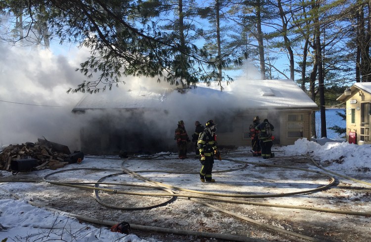 Firefighters work to extinguish a fire at 14 Golden Way in New Gloucester on Friday. The stubborn fire started under the home and spread through the walls.