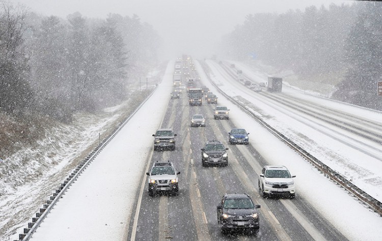 Vehicles make their way along the Maine Turnpike in Saco as snow falls Thursday. The speed limit has been reduced to 45 mph from the New Hampshire border to Augusta.