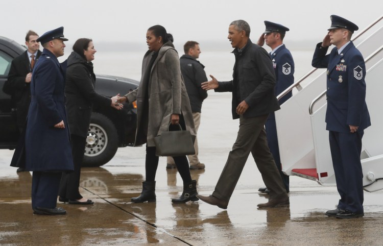 President Obama and first lady Michelle Obama are greeted Monday as they disembark from Air Force One at Andrews Air Force Base in Maryland. They were en route to Washington as they returned from their annual vacation in Hawaii.