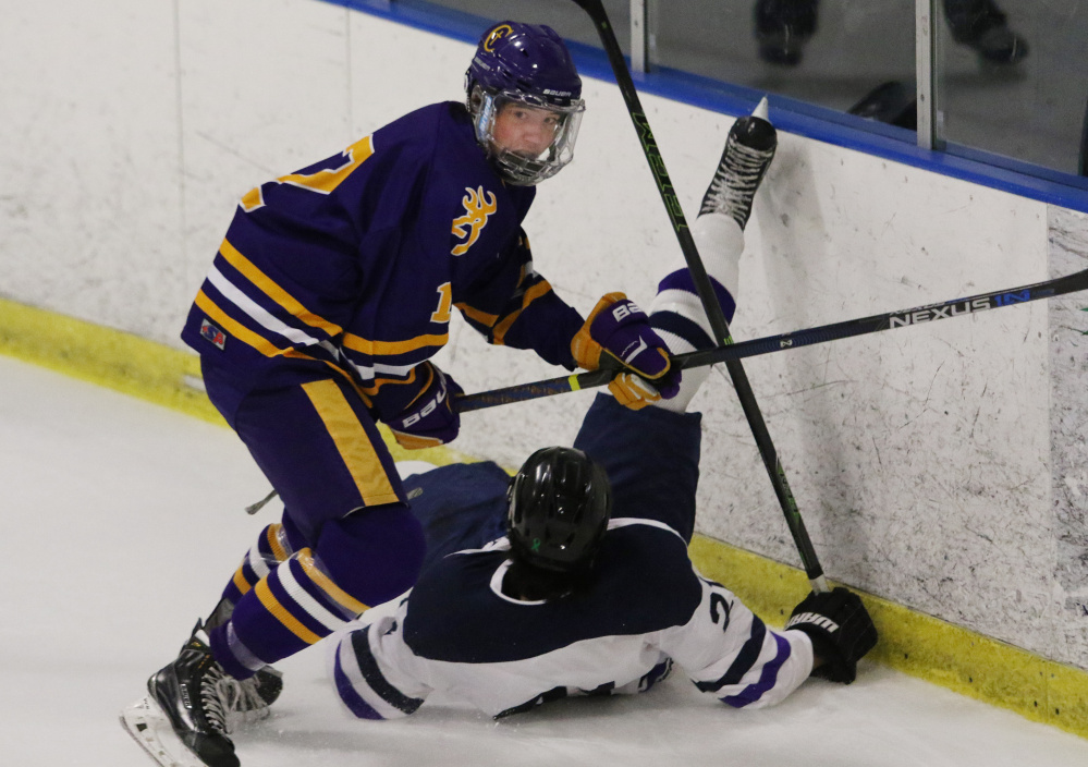 Cheverus' Jesse Pierce turns up ice after checking Portland/Deering's Joe Herboldsheimer during the first period Monday. Pierce scored in the third period to give the Stags a 4-2 lead.