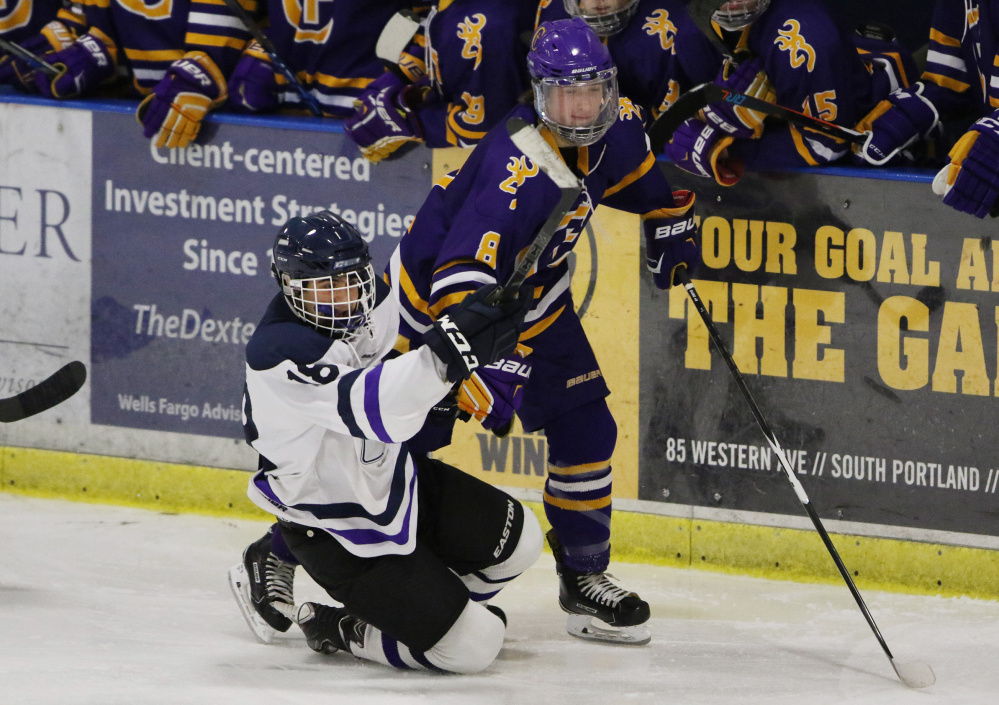 Portland/Deering's Cam Clifford, left, falls after colliding with Cheverus' Cam Dube during the second period of their game Monday. Dube had two assists for the Stags, who beat the Rams 5-2 to win the City Cup for the fourth straight year.