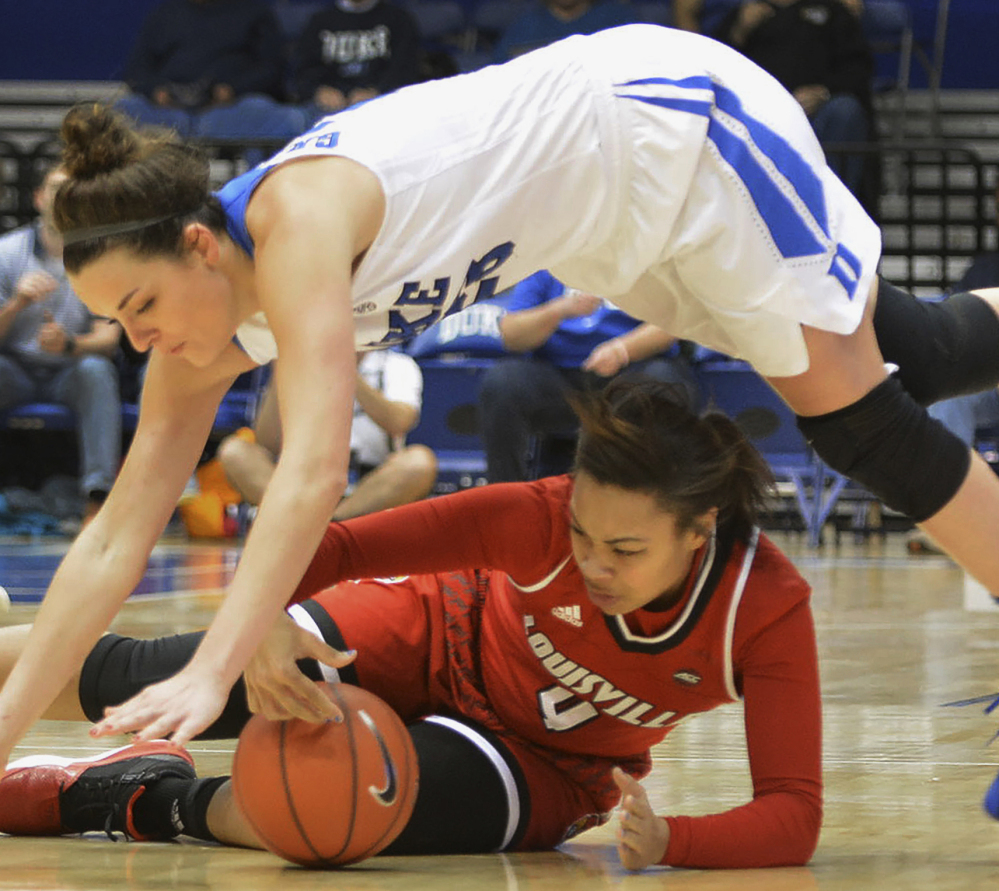Duke's Rebecca Greenwell battles Louisville's Mariya Moore for a loose ball in Monday night's game at Durham, North Carolina. Duke won its ninth straight, 58-55.