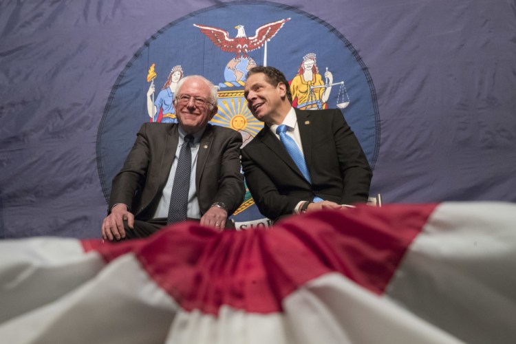 New York Gov. Andrew Cuomo, right, and Vermont Sen. Bernie Sanders appear onstage together during an event at LaGuardia Community College in New York. Under the Cuomo's plan, which requires legislative approval, any college student accepted to a New York public university or two-year community college is eligible to attend for free, provided their family earns less than $125,000.