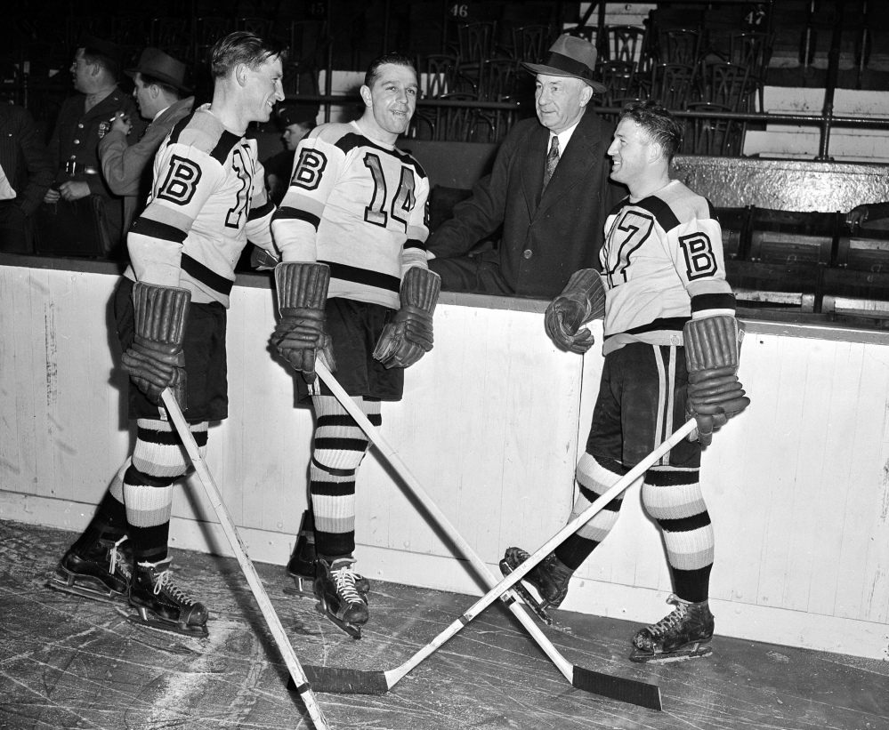 In this Oct. 23, 1945 photo, Boston Bruins Manager "Uncle Arthur" Ross is pictured with his players, from left, Milt Schmidt, Porky Dumart and Bobby Bauer – known as the team's "Kraut Line" – during hockey practice. Schmidt, a hockey hall of famer, died Wednesday at the age of 98, Bruins team spokesman Matt Chmura said. Associated Press