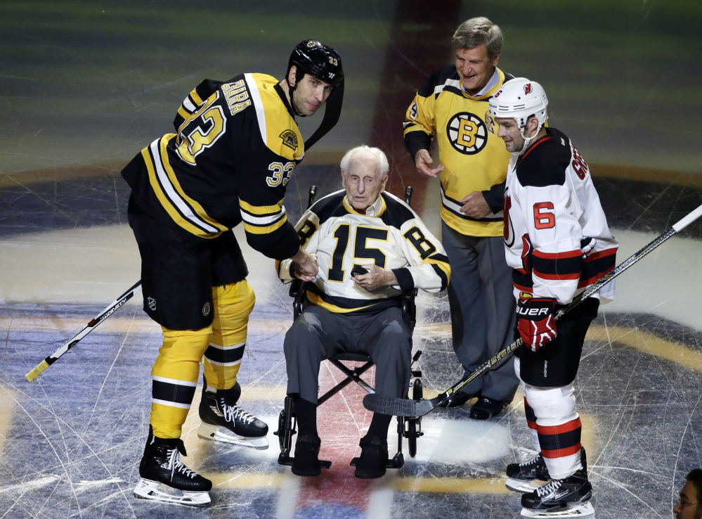 In this Oct. 20, 2016 photo, Boston Bruins defenseman Zdeno Chara , left, and New Jersey Devils defenseman Andy Greene join Bruins legends Milt Schmidt and Bobby Orr in a ceremonial puck drop before an game in Boston. Schmidt, a hockey hall of famer, died Wednesday at the age of 98, Bruins team spokesman Matt Chmura said Wednesday. He was the league's oldest living former player. Associated Press/Elise Amendola