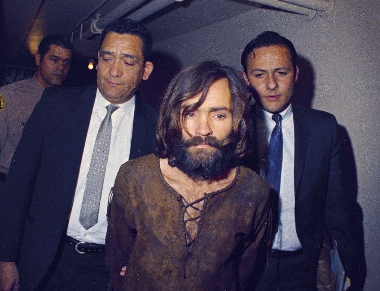 Charles Manson is escorted to his arraignment on conspiracy-murder charges in connection with the Sharon Tate murder case in 1969.