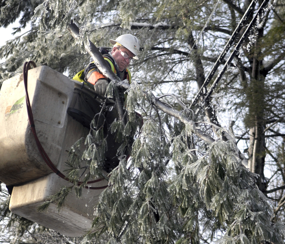 Central Maine Poweer lineman Wayne Piper removes a limb from a power line Wednesday in Manchester.