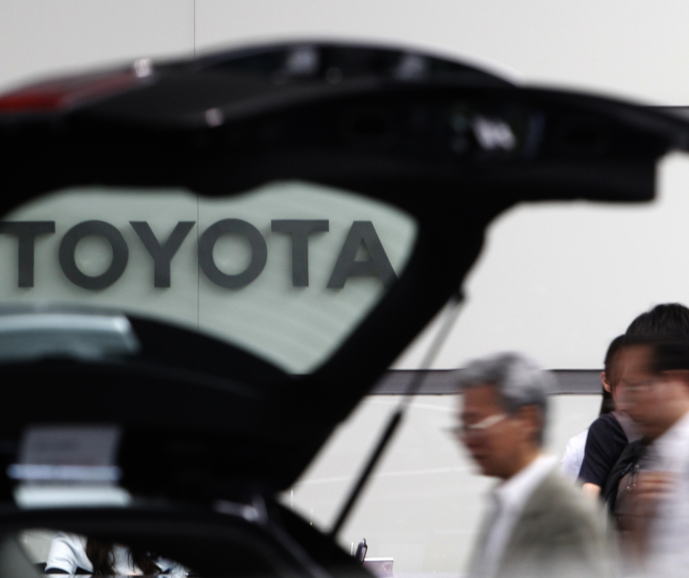 People look at a car on display at Toyota's Tokyo headquarters. President-elect Donald Trump has threatened Toyota for building its products in Mexico rather than the U.S.