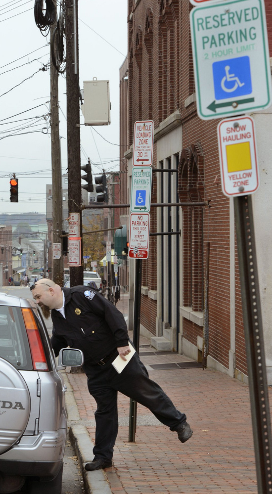 Portland parking officer Andy Martin patrols the Old Port in Portland looking for illegal handicapped parking.