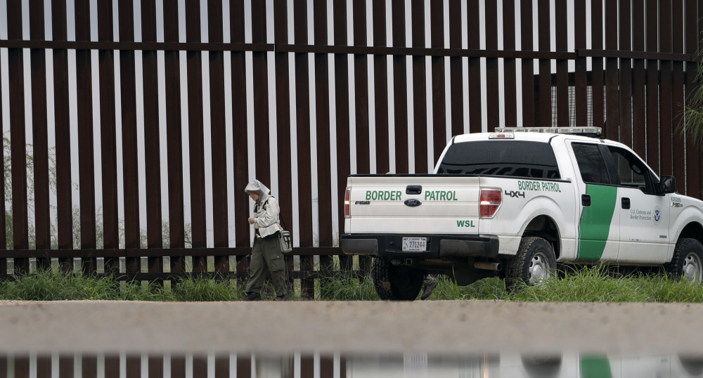 A U.S. Customs and Border Patrol agent passes birdwatcher Nancy Hill, 81, along a section of the border wall in November in Hidago, Texas.