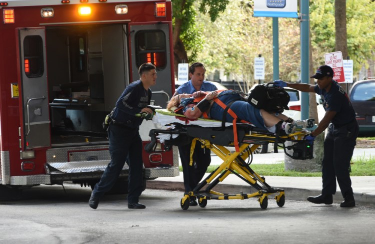 An injured woman is taken into Broward Health Trauma Center in Fort Lauderdale, Fla., after a shooting at the Fort Lauderdale-Hollywood International Airport on Friday.