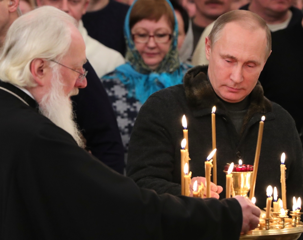 Russian President Vladimir Putin lights a candle prior to a midnight Orthodox Christmas Mass at the St. George's Monastery, Novgorod Region, about 300 miles northwest of Moscow, on Friday. Orthodox Christians celebrate Christmas on Jan. 7, in accordance with the Julian calendar.