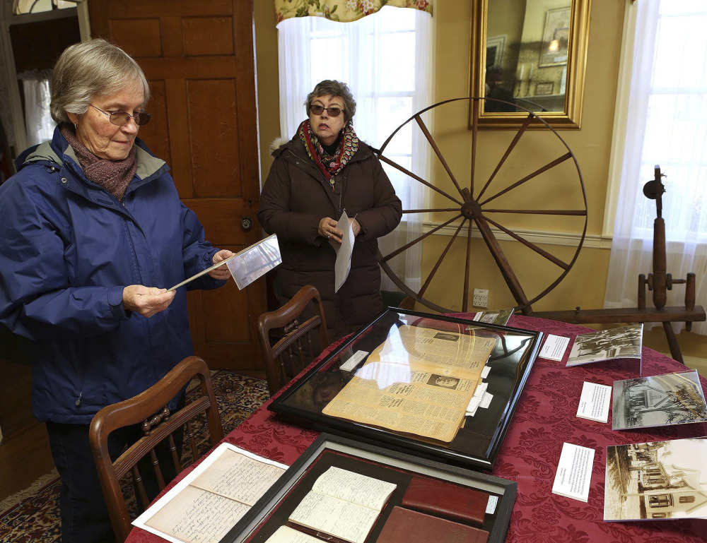 Ellington Historical Society Archivist Lynn Fahy, left, and Curator Nancy Long, right, look over Charles Price's diaries at the Nellie McKnight House in Ellington, Conn. Eight of the former town assessor's diaries were found and provide  first hand insight into history.