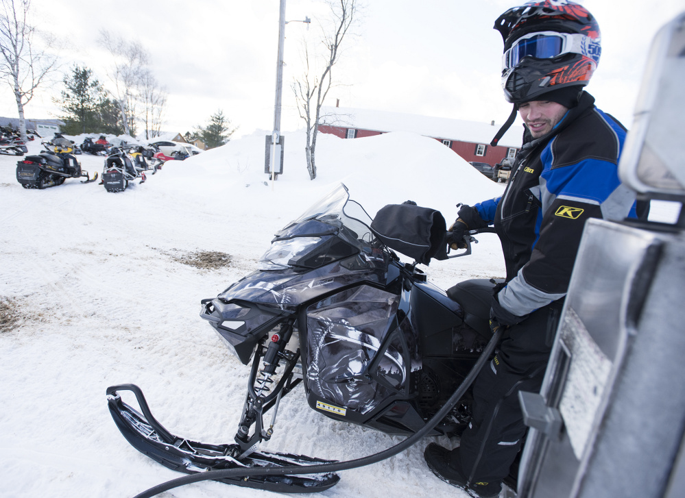 Ryan Kelly, of Cumberland, Rhode Island, gasses up at Shin Pond Village. The outfit is renting snowmobiles again for the first time in years and is exploring expansion to serve four-season clientele.