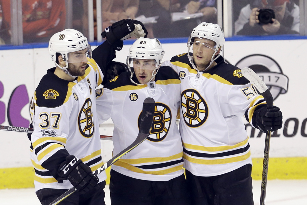 Boston left wing Brad Marchand, center, celebrates with teammates Patrice Bergeron, left, and Ryan Spooner after scoring his second goal against the Florida Panthers in the second period of Saturday's game at Sunrise, Fla. (Associated Press/Alan Diaz)
