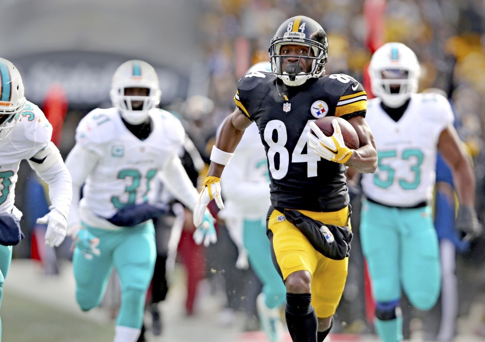 Miami's Michael Thomas, 31, and Jelani Jenkins, 53, fail to stop Pittsburgh's Antonio Brown, who scored two first-half touchdowns in the Steelers' 30-12 win in their AFC first-round playoff game Sunday in Pittsburgh.