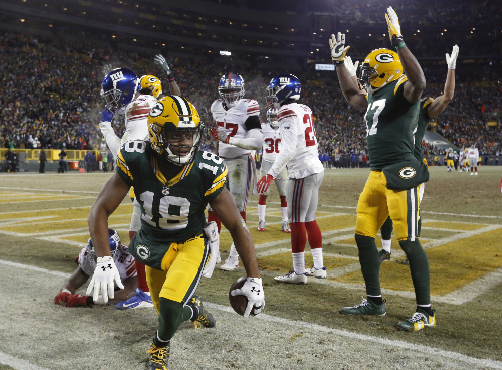 Packers wide receiver Randall Cobb celebrates after catching a Hail Mary from quarterback Aaron Rodgers to end the first half Sunday in Green Bay, Wisconsin. The 42-yard touchdown pass sparked the Packers to a 38-13 win over the Giants in their first-round playoff game.