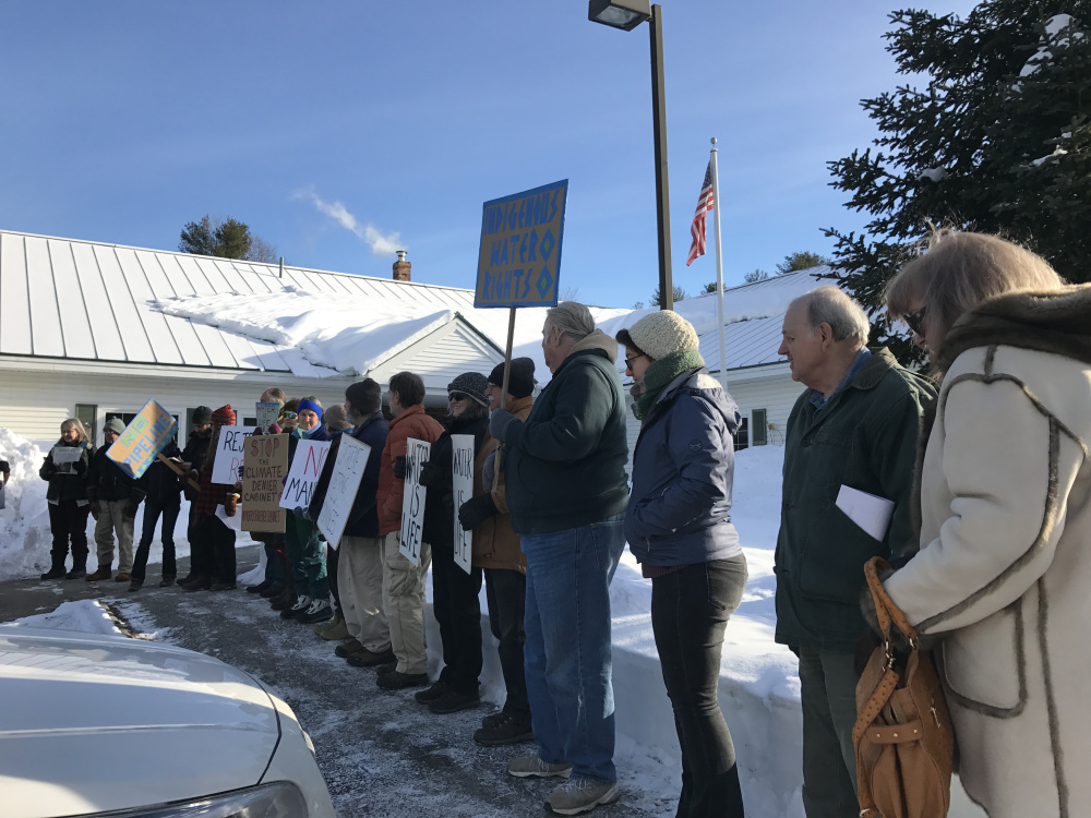 Protesters line up in the cold Monday before submitting a petition at the Augusta office of Sen. Angus King, asking him to reject President-elect Donald Trump's nominees.