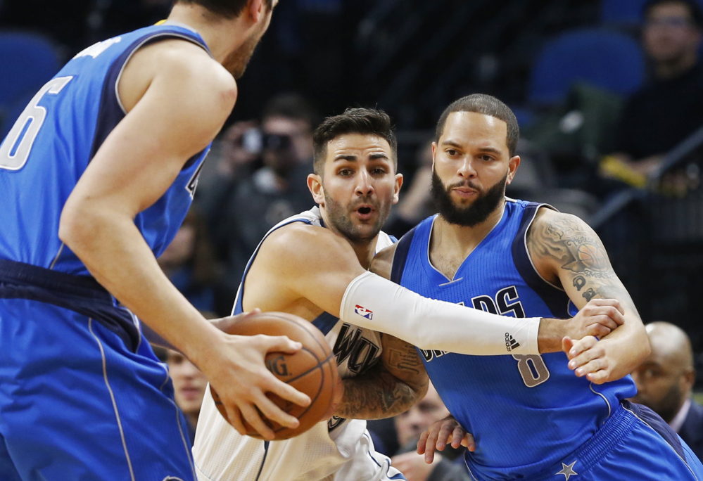Minnesota's Ricky Rubio, center, defends Dallas' Deron Williams, right, during the Timberwolves 101-92 win Monday night in Minneapolis. Minnesota snapped a four-game losing streak with the win.