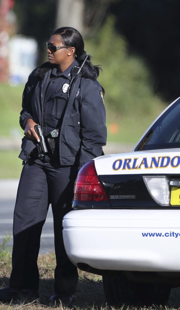 An Orlando police officer secures the area around John Young Parkway and Silver Star Road on Monday after a fellow officer was shot while on duty nearby.