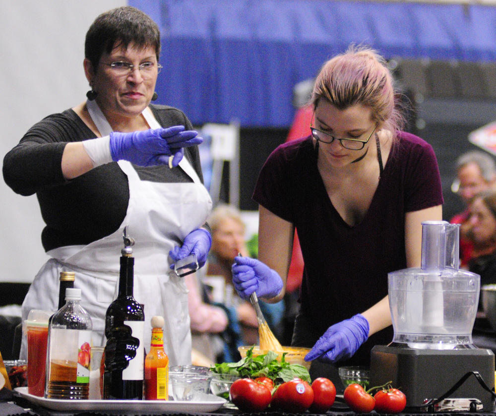Cynthia Finnemore-Simonds, left, and Elizabeth Simonds do a cooking demonstration featuring Backyard Farms tomatoes during the Maine Agricultural Trades Show on Tuesday at the Augusta Civic Center.