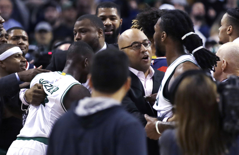 Jae Crowder of the Boston Celtics, right, is held back by assistant coach Micah Shrewsberry from continuing a confrontaion with John Wall of the Washington Wizards following the Celtics' victory at home Wednesday night.