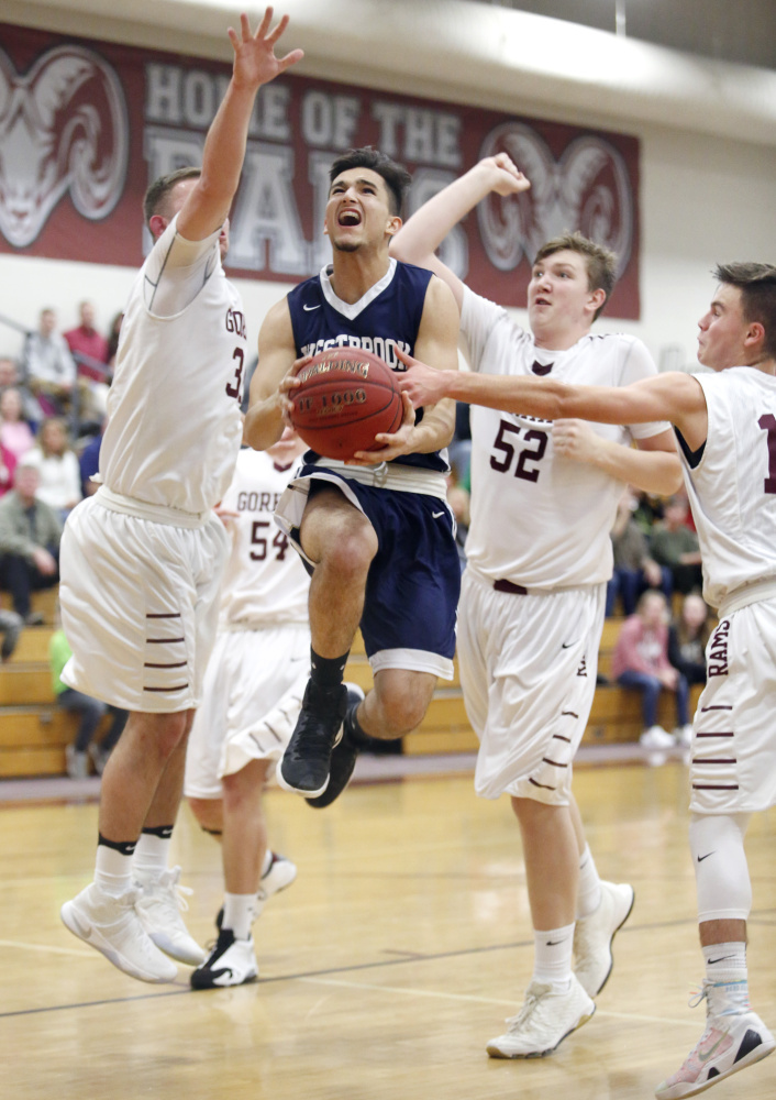 Hamza Hanifi of Westbrook finds room down the lane Thursday night to drive to the basket against the Gorham defense in the second quarter. Guarding for Gorham are Logan Drouin, left, Bryce Womack, 52, and Jackson Potter. Westbrook scored a 53-34 victory in an SMAA game at Gorham High.