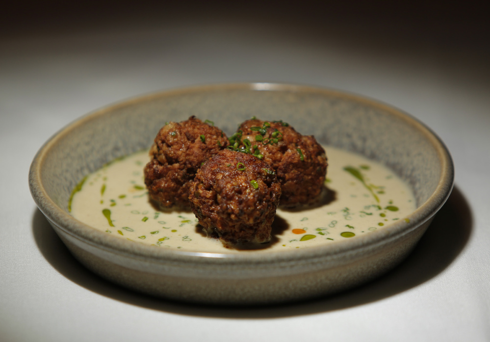 Albondigas de cordero, a hot tapas plate of seared lamb meatballs served in oxtail jus and sherry cream at Toroso.