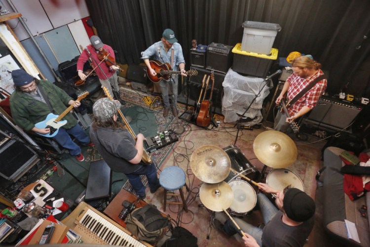 The Mallett Brothers Band, clockwise from left, Wally Wenzel on electric guitar, Andrew Martelle on fiddle, Will Mallett on acoustic guitar, Luke Mallett on electric guitar, Chuck Gagne on drums and Nick Leen on bass, rehearse songs from their new album last week at their Portland recording studio.
