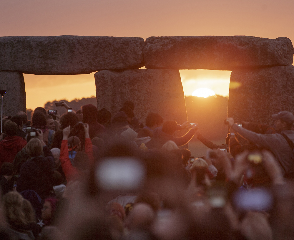 The sun rises as thousands of revelers gather at Stonehenge to celebrate the summer solstice.