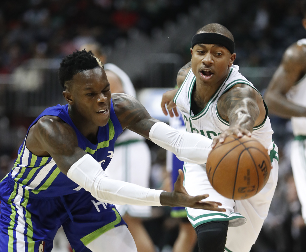 Atlanta Hawks guard Dennis Schroder, left, and Boston Celtics guard Isaiah Thomas chase down a loose ball during the first half of Friday's game in Atlanta. (Associated Press/John Bazemore)